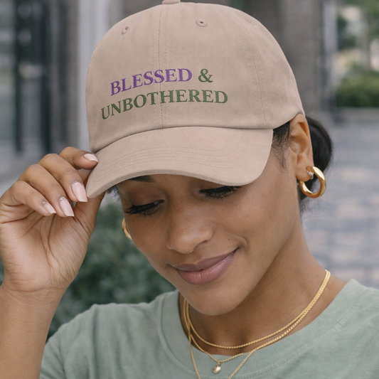 Black woman wearing sage “blessed and unbothered” dad hat styled with neutral outfit and gold jewelry, minimal everyday look