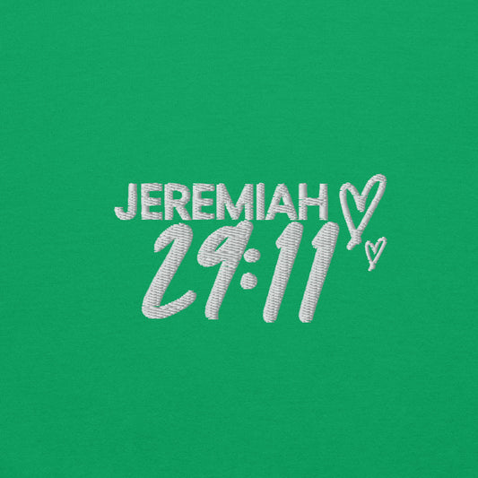 Zoomed in view of text Jeremiah 29.11 embroidery in white on a green sweater